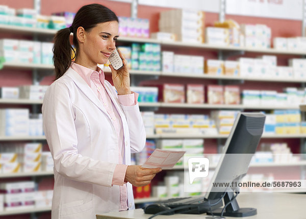 Pharmacist talking on phone at counter