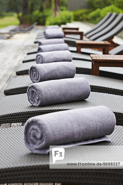 Rolled towels on lawn chairs outdoors