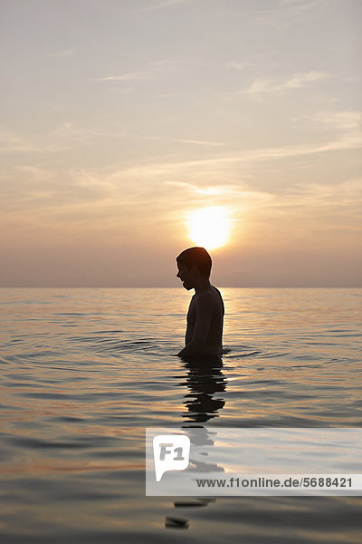 Teenager-Junge im Wasser stehend