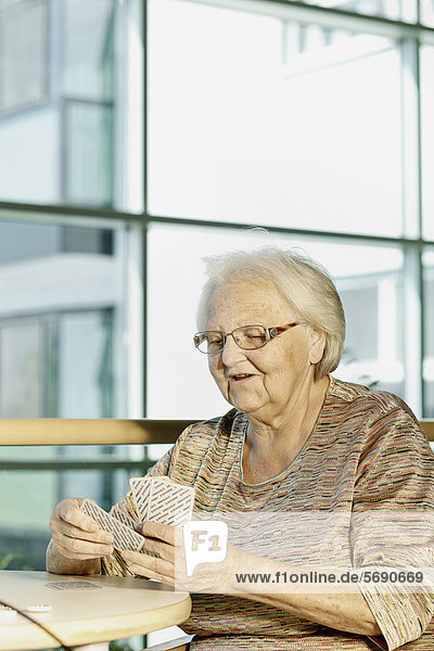 Alte Frau beim Kartenspiel