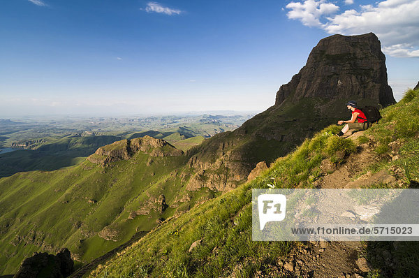 Sitzende Frau bewundert Landschaft  Sentinel Hiking Trail  Wanderweg  Drakensberge  KwaZulu-Natal  Südafrika  Afrika