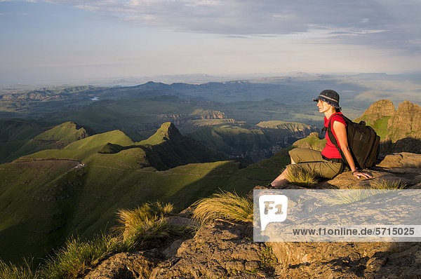 Sitzende Frau bewundert Landschaft  Sentinel Hiking Trail  Wanderweg  Drakensberge  KwaZulu-Natal  Südafrika  Afrika