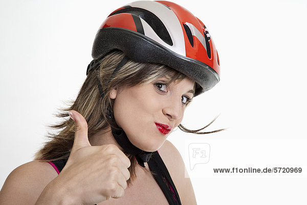 Junge Frau im Fahrradhelm mit Daumen nach oben Zeichen