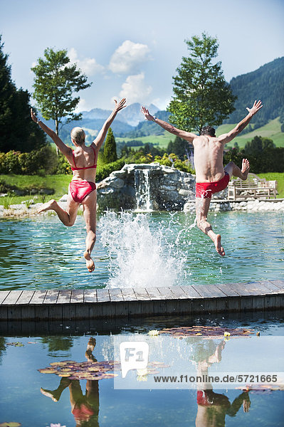 Austria  Salzburg County  Couple jumping into swimming pool
