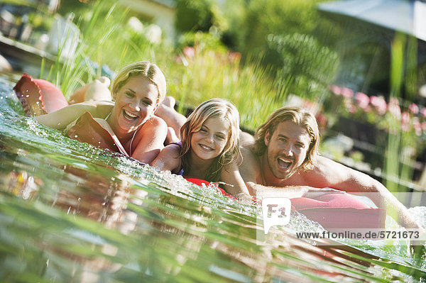 Österreich Salzburger Land Familie auf Luftmatratze im Naturbad