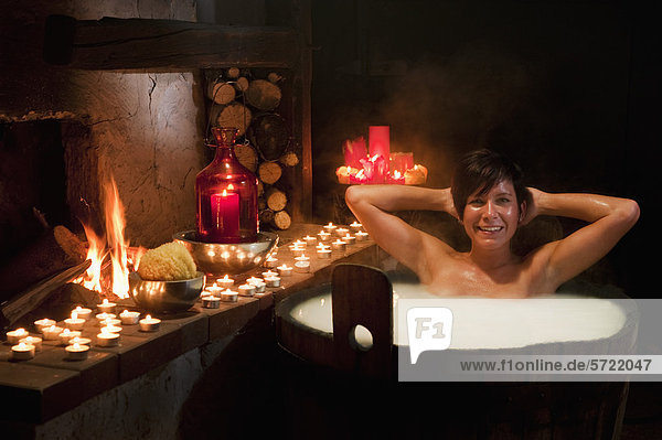 Austria  Salzburg County  Young woman taking bath in wooden tub