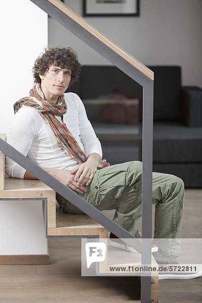 Young man sitting on steps at home  portrait