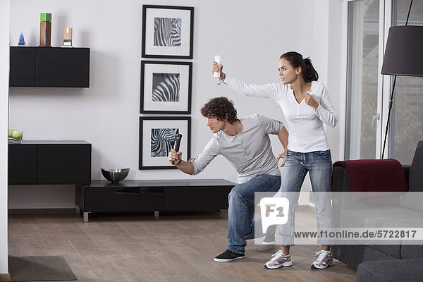 Germany  Bavaria  Young couple playing with game console