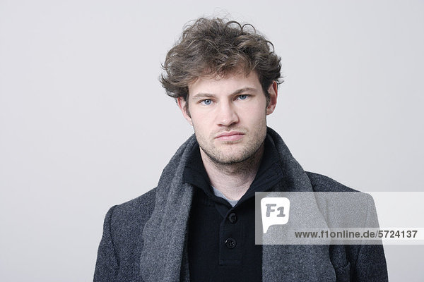 Man with grey coat against white background  close up