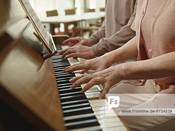 Germany  Cologne  Senior couple playing piano in nursing home