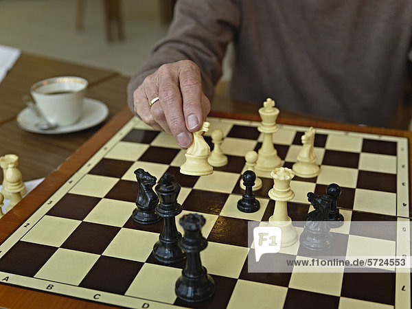 Älterer Mann beim Schachspielen im Pflegeheim