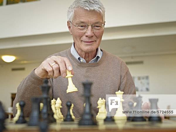 Älterer Mann beim Schachspielen im Pflegeheim