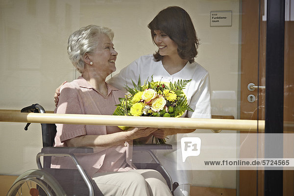 Hausmeisterin schenkt Seniorenfrauen im Pflegeheim Blumenstrauß