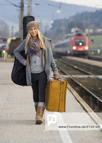 Austria  Teenage girl with suitcase on train station