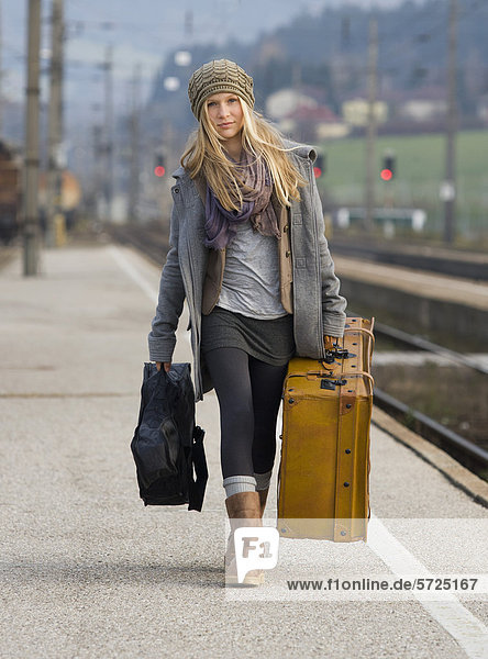 Österreich  Teenagermädchen mit Koffer am Bahnhof