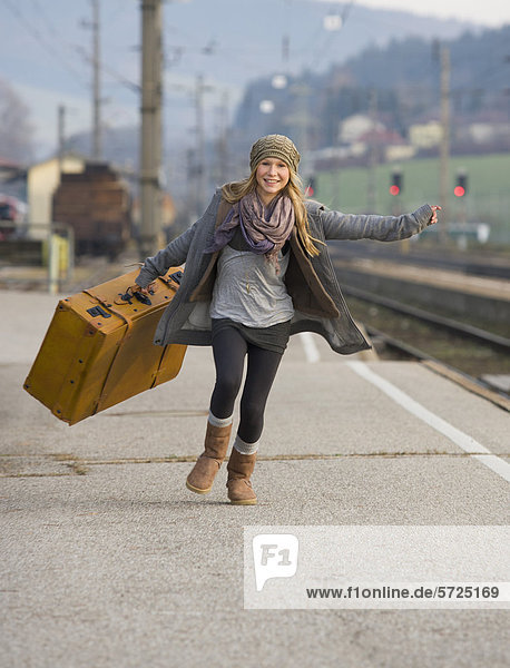 Österreich  Teenager-Mädchen auf dem Bahnhof mit Koffer