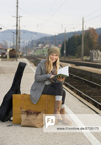 Österreich  Teenagermädchen mit Koffer am Bahnhof