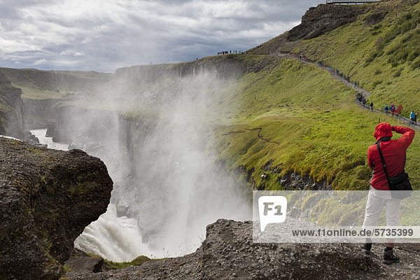Tourist am Rande des Gullfoss Wasserfalls  Island