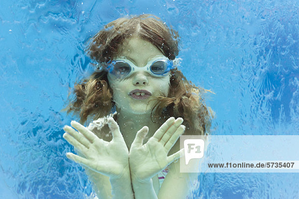 Mädchen mit Schutzbrille im Schwimmbad schwimmend