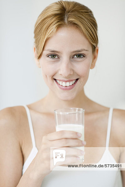 Young woman holding glass of milk  portrait