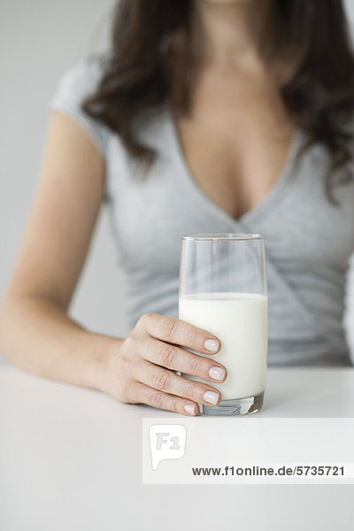 Frau hält ein Glas Milch in der Hand