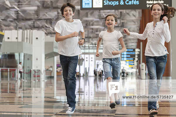 Siblings running in airport