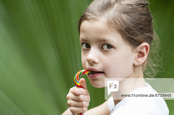 Girl eating candy  looking over shoulder