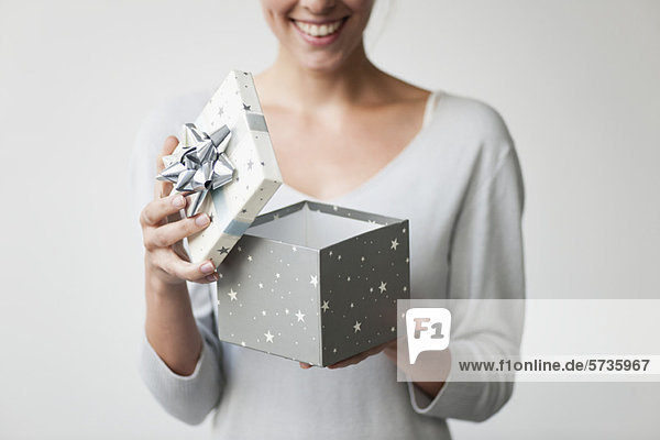 Frau öffnet Geschenkschachtel  beschnitten