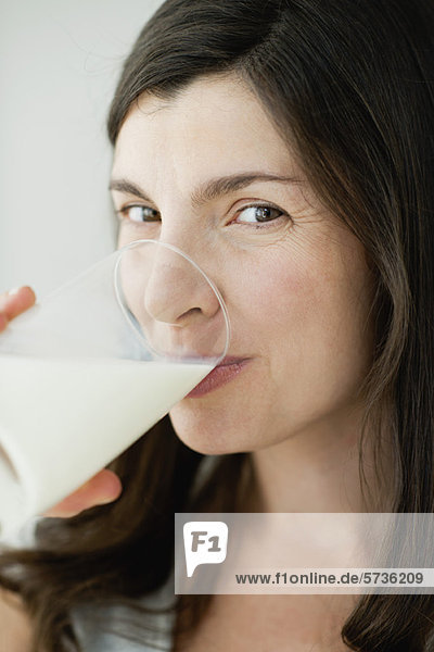 Mittlere Erwachsene Frau trinkt ein Glas Milch