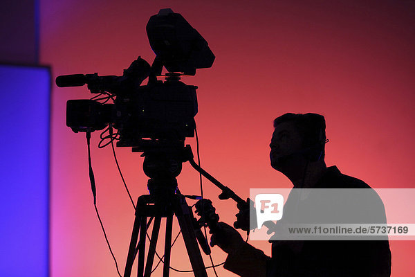 Cameraman with a TV camera on a tripod  silhouette
