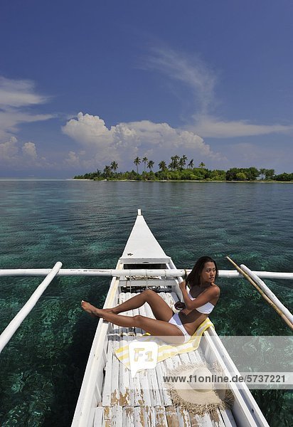Asien  Philippinen  Bohol  Frau Sonnenbaden am Boot