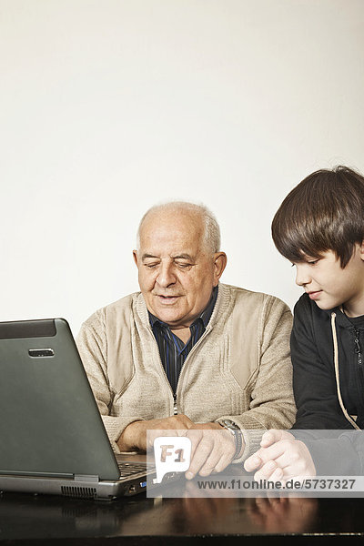 Senior und Junge am Laptop