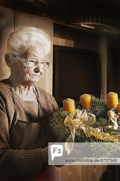 Alte Frau mit Adventkranz