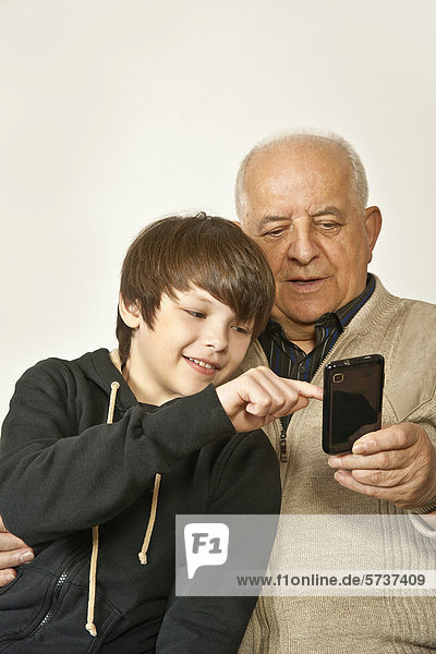 Old man and a boy playing with a smartphone