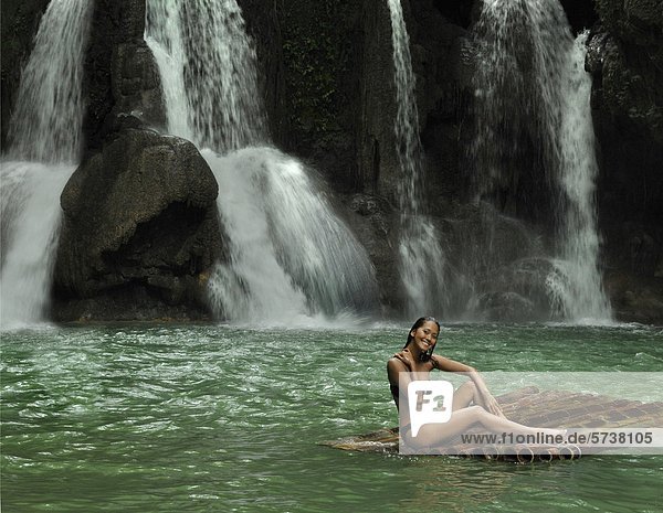 Asien  Philippinen  Mag-Aso  Frau in einem Teich mit Wasserfall