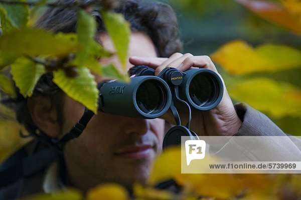 Man looking through binoculars                                                                                                                                                                      