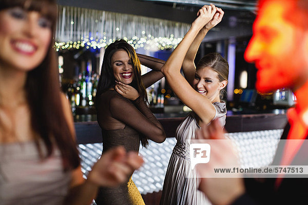 Smiling friends dancing in bar