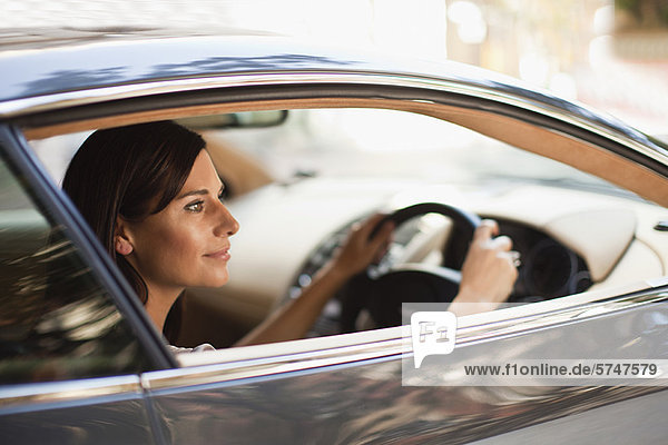 Smiling woman driving sports car