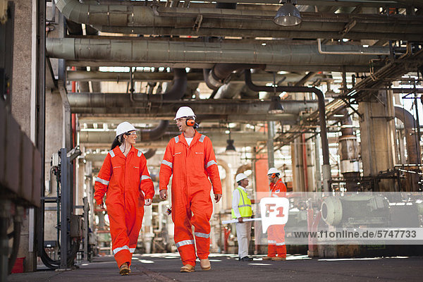 Arbeiter  die in der Ölraffinerie spazieren gehen