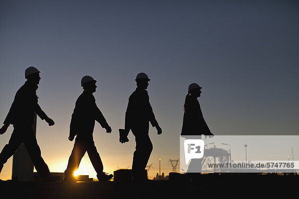 Silhouette der Arbeiter in der Ölraffinerie