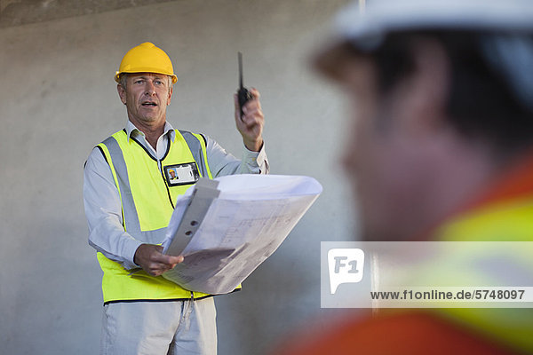 Worker holding blueprints on site
