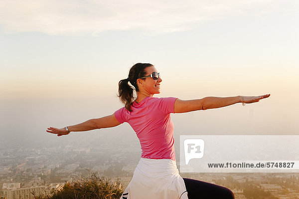 Woman stretching on hilltop