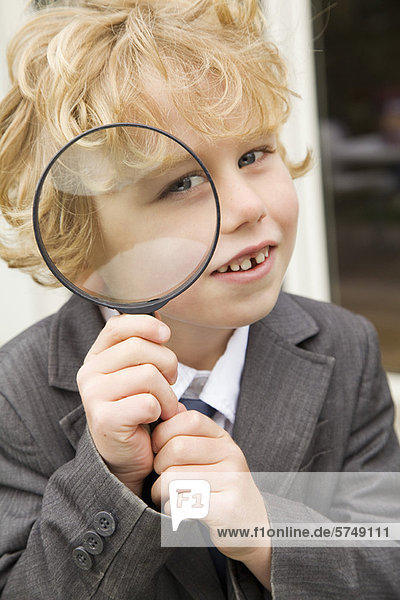 Boy using magnifying glass outdoors
