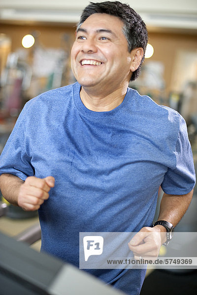 Mann mit Laufband im Fitnessstudio