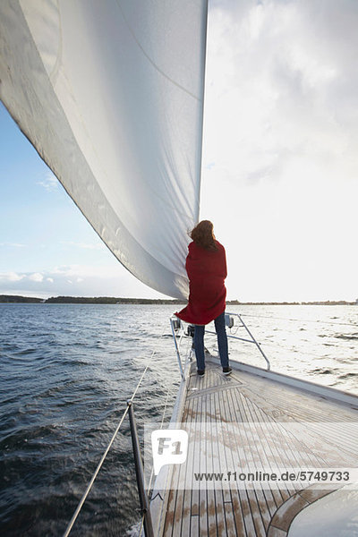 Woman standing by sail on yacht