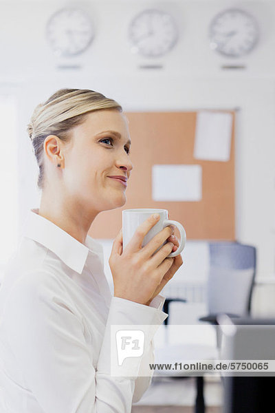 Woman drinking coffee in office