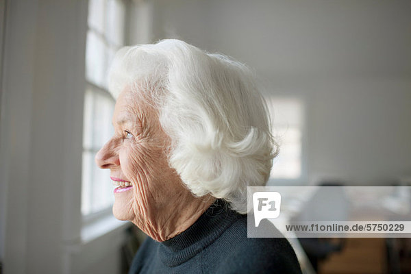 Porträt einer älteren Frau mit Blick aus dem Fenster