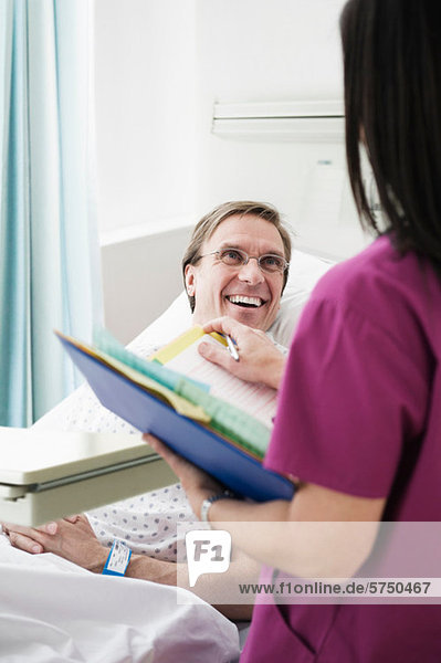 Krankenschwester kümmert sich um lächelnde Patienten im Krankenhaus