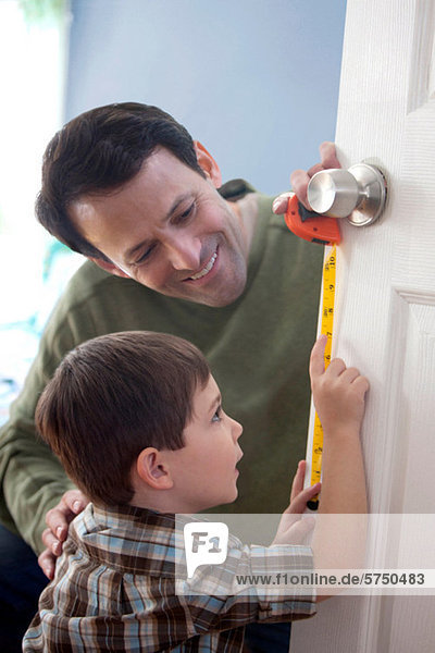 Vater und Sohn messen Tür zu Hause