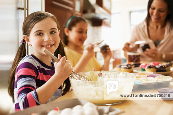 Porträt eines Mädchens  das mit seiner Familie in der Küche Kuchen backt.